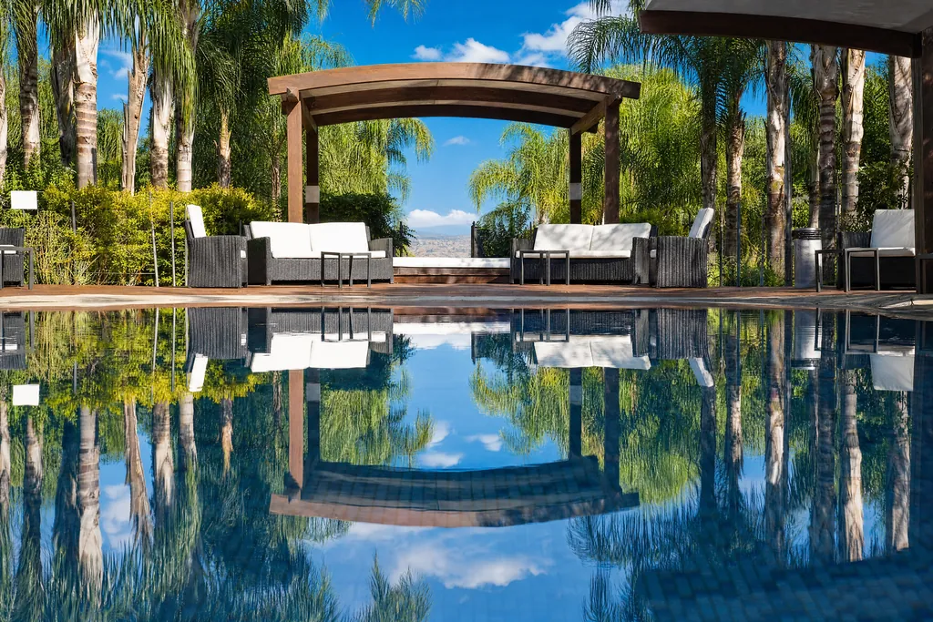 The pool and pergola reflected in the water